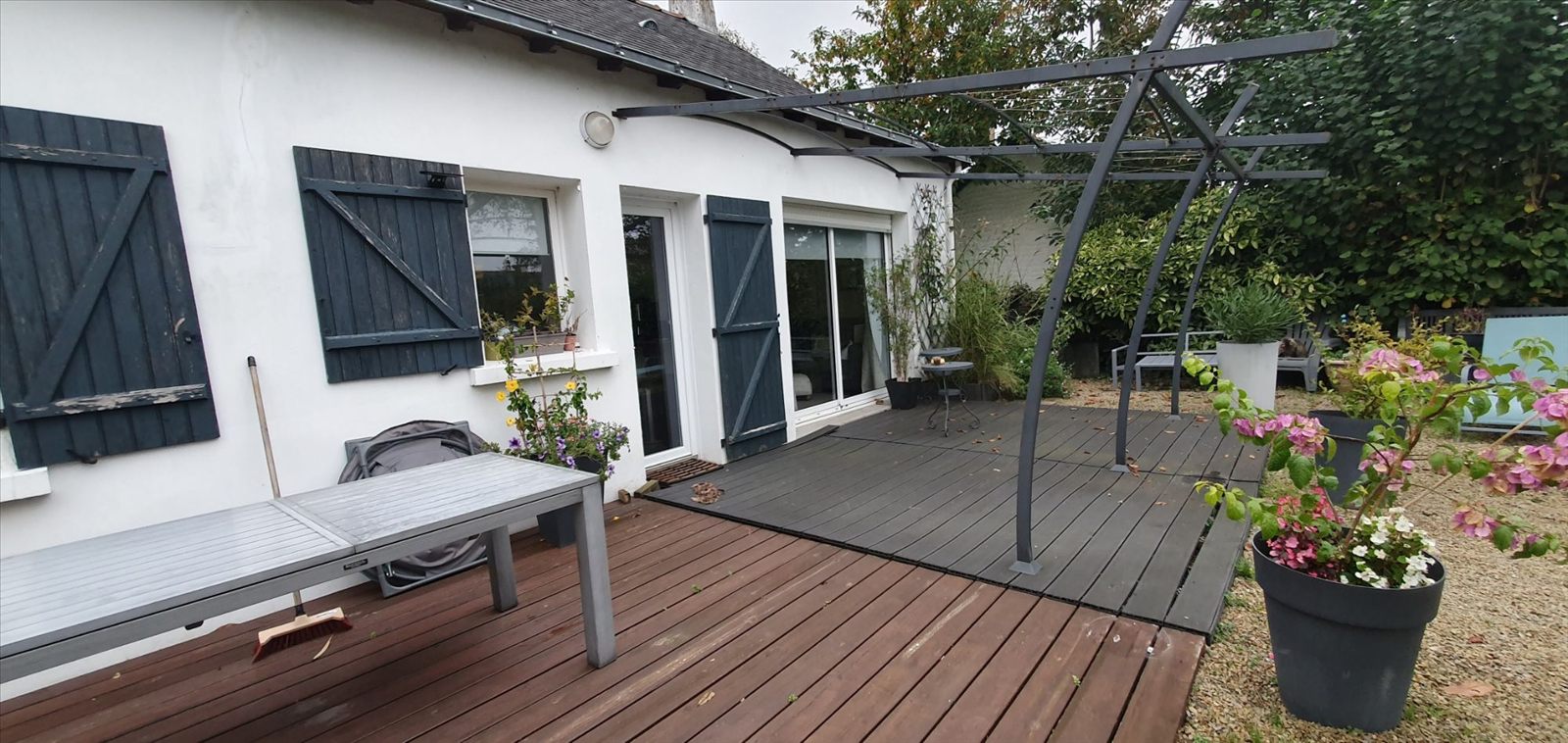 Ancienne terrasse en composite anthracite sous la pergola, prolongée par un platelage bois brun