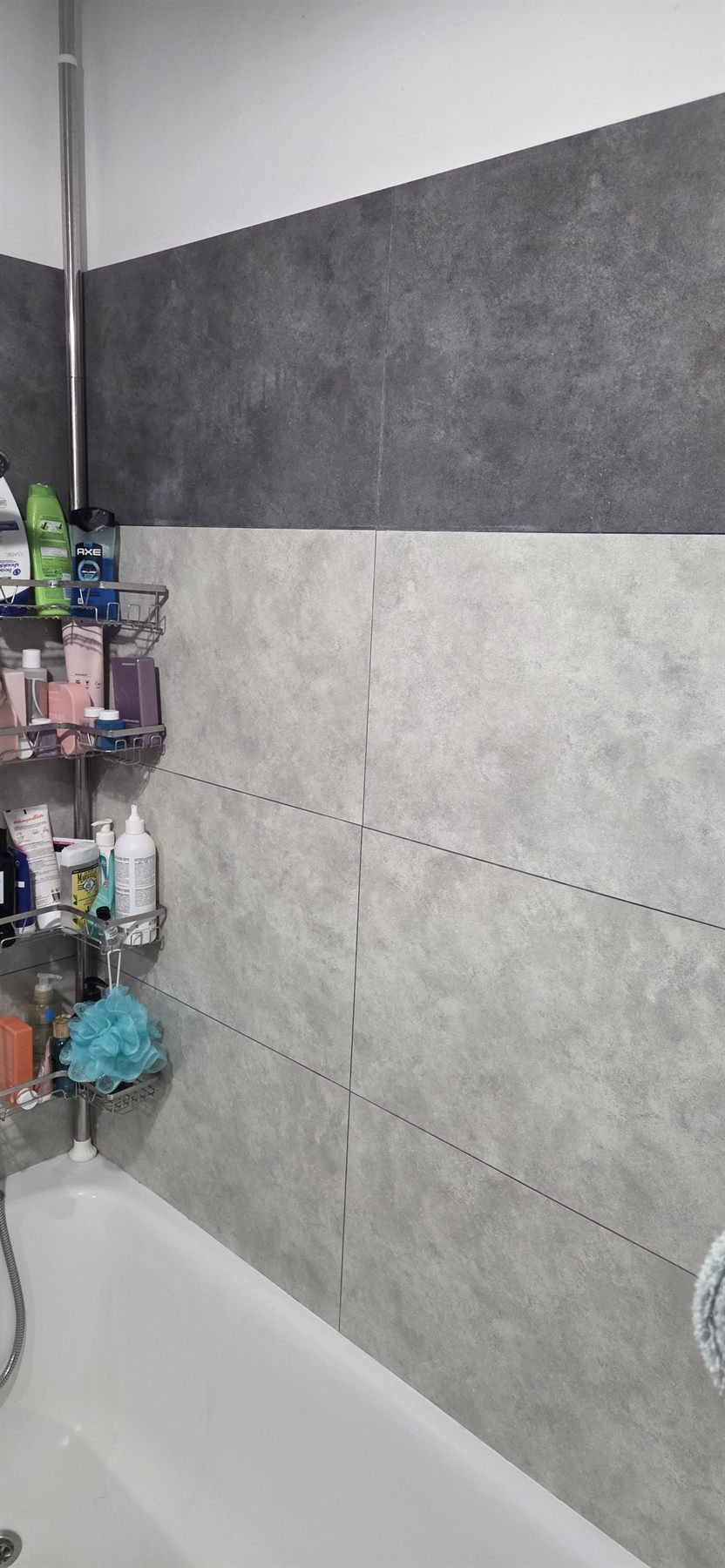 Mur de baignoire-douche habillé de dalles PVC Dumawall gris clair et gris foncé, 9 ans après la pose