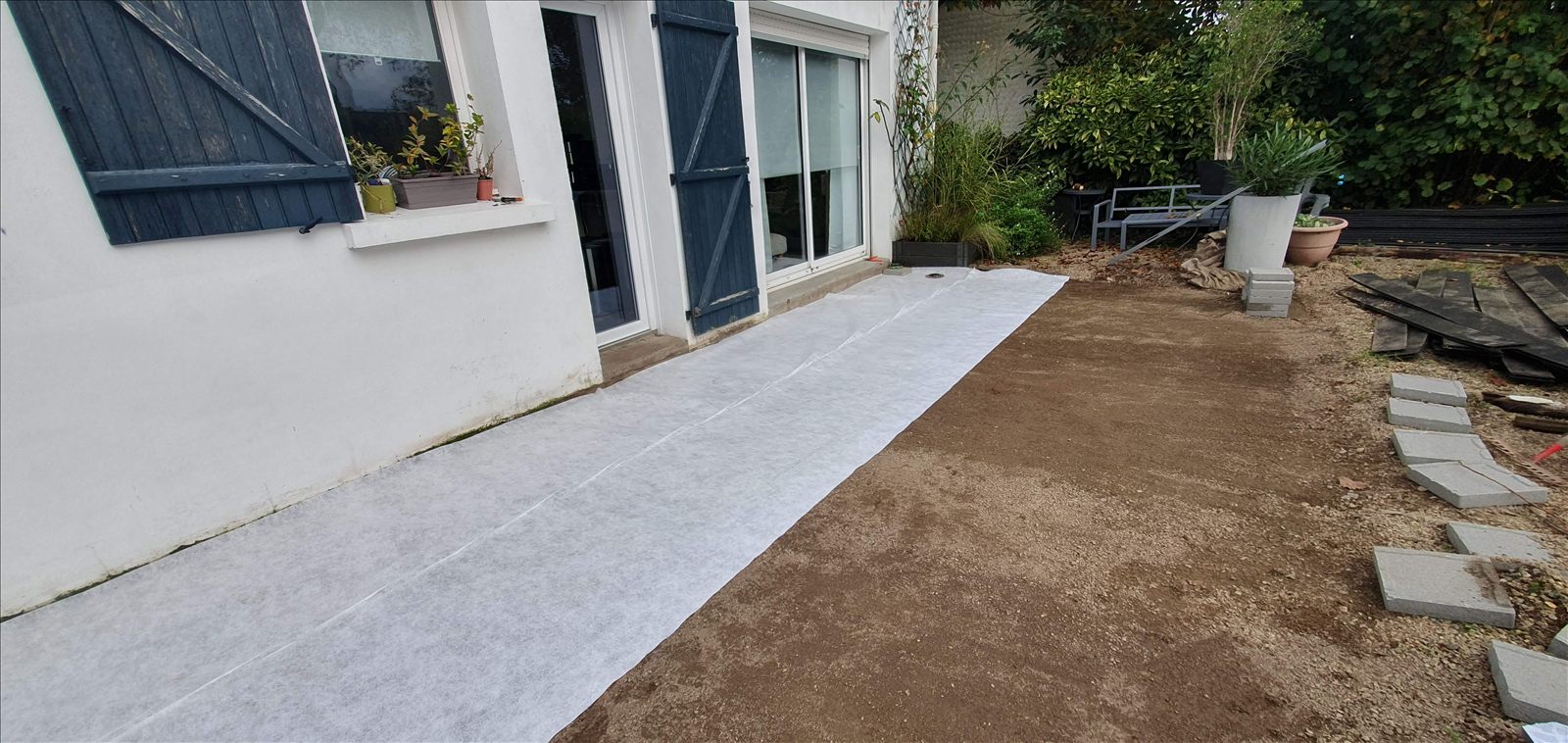 Géotextile blanc déroulé contre la façade