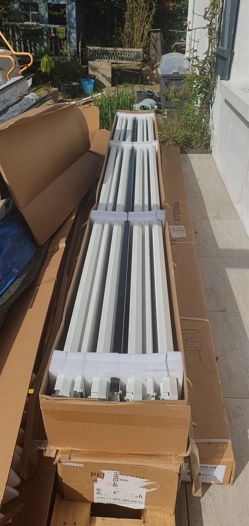 Lames blanches de la pergola dans leur carton